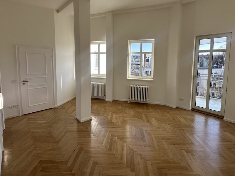 Heller Wohnraum mit Parkett, großen Fenstern und modernem Ausbau
