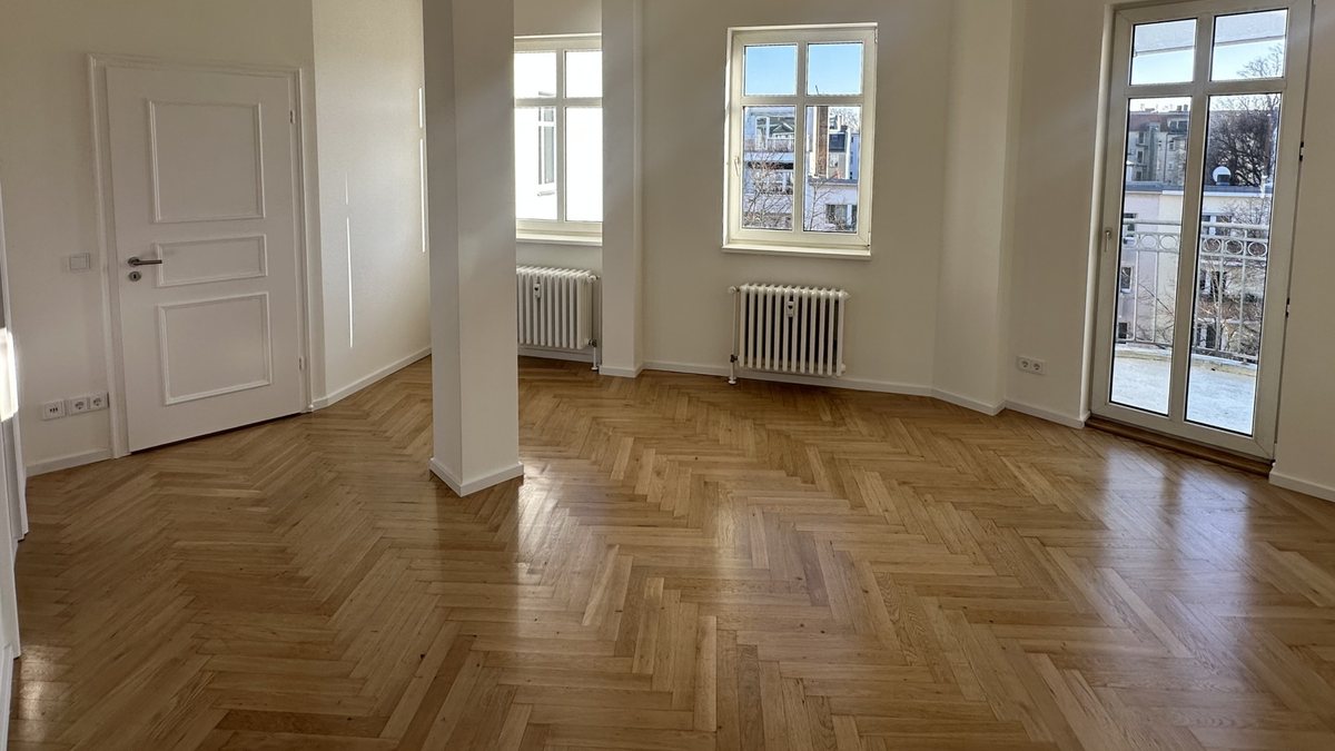 Heller Wohnraum mit Parkett, Stuckdecke und Balkon